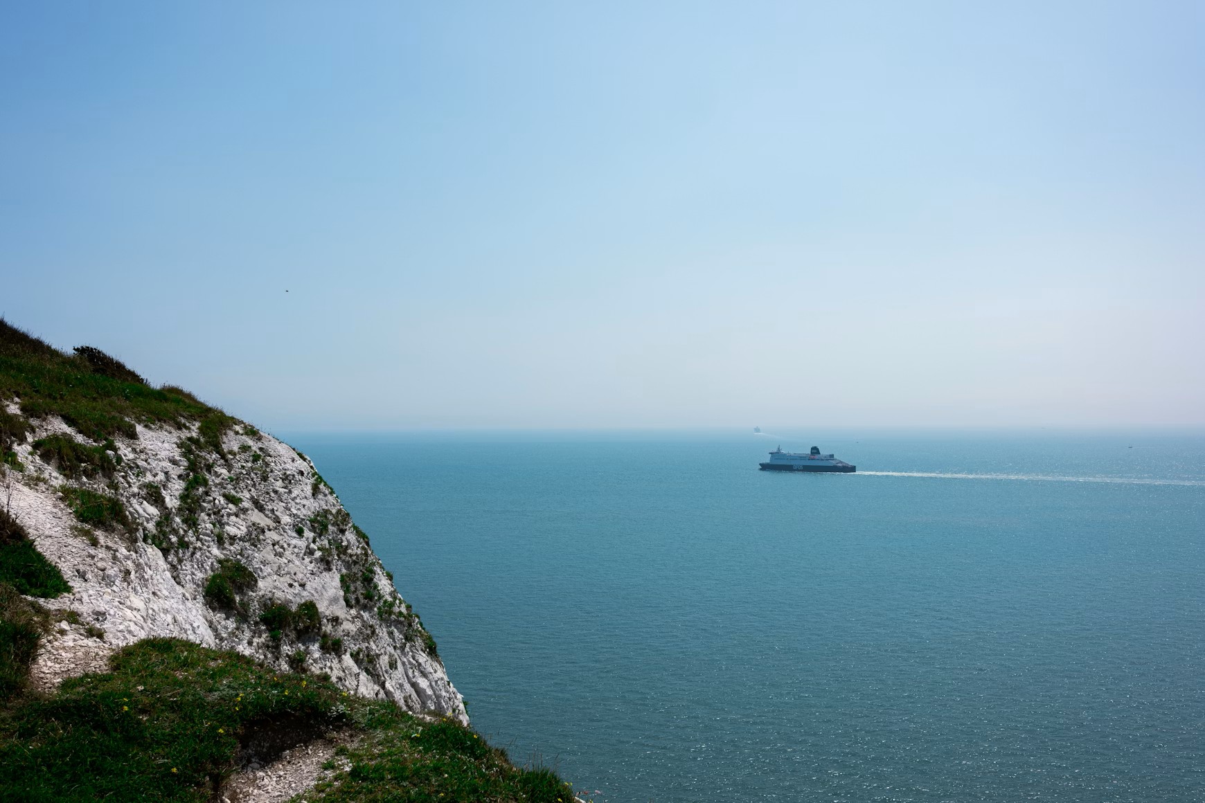Ferry sailing on the ocean near white cliffs